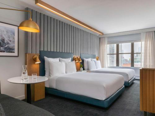 芝加哥21c Museum Hotel Chicago的酒店客房设有两张床和一张桌子。