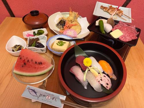 本宫Villa KUMANO的一张桌子,上面放着一碗寿司和其他食物