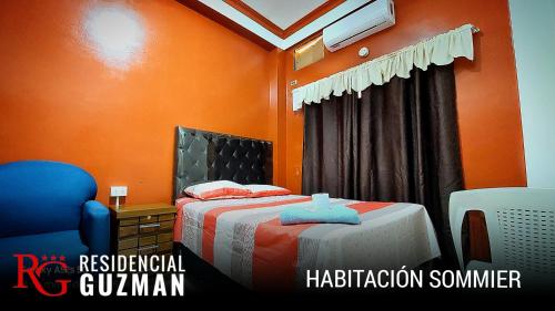 亚奎巴Residencial Guzmán 1的一间卧室配有一张橙色墙壁的床