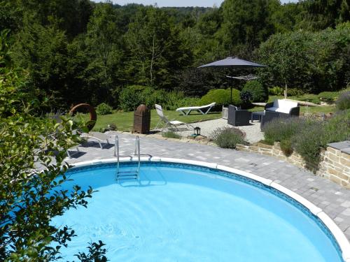 维勒斯第六感酒店的一个带遮阳伞的庭院里的大型蓝色游泳池