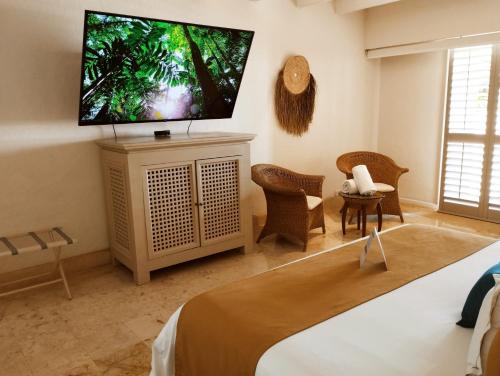 Barra Vieja阿卡普尔科第三生命酒店的卧室配有壁挂式平面电视。