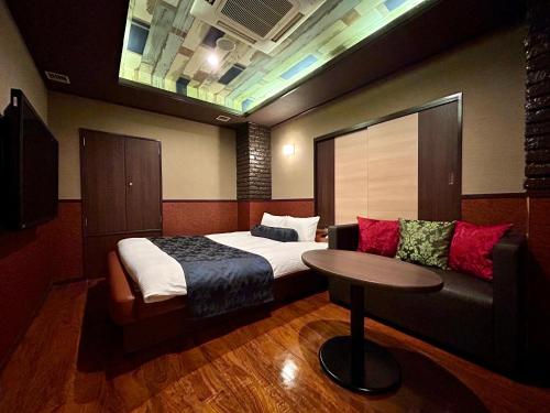 东京Hotel Asian Color (Adult Only)的一间卧室配有一张床、一张桌子和一张沙发