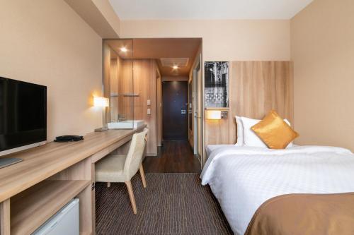 仙台仙台远景酒店的酒店客房配有一张床、一张书桌和一台电视。