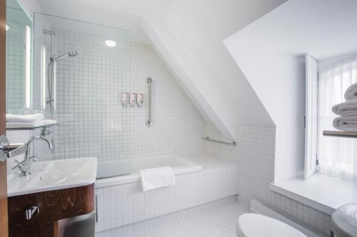 魁北克市蒙娜斯提尔奥古斯丁酒店的白色的浴室设有浴缸和水槽。