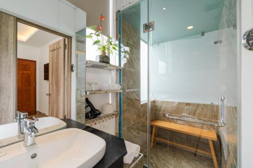 大叻California Hotel的一间带水槽和玻璃淋浴的浴室