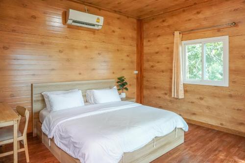 Ban Laem BuaBeung Sampathuan Nakornchaisri Resort的小木屋内一间卧室,配有一张床