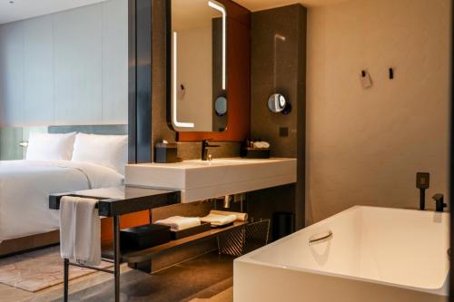成都成都 AC 酒店的酒店客房设有床、水槽和浴缸。