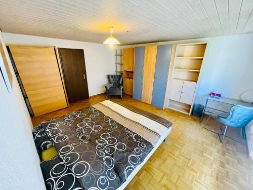KönizSehr gemütliches und gepflegtes Zimmer 8 Km von Bern-City的一间卧室配有一张床、一张桌子和一把椅子