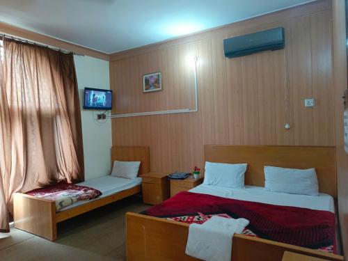穆扎法拉巴德SEE MOTEL的一间酒店客房,设有两张床和电视