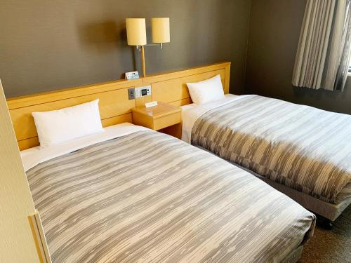 盛冈盛冈站前干线酒店的一间酒店客房,房间内设有两张床