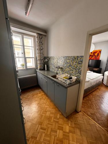 萨尔茨堡Guesthouse Mozart - Apartment House的一个带水槽的厨房和一张位于客房内的床