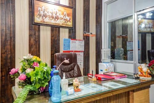 PhundardihHotel O Welcome Sri的一个带玻璃柜台、椅子和鲜花的沙龙