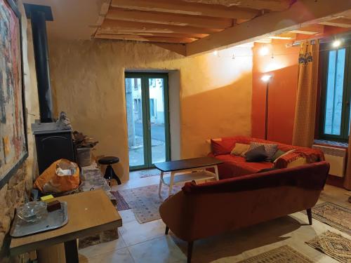 SiguerGîte Groupe La Farigoule à Siguer的客厅设有红色的沙发和壁炉