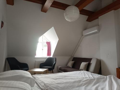 蒂豪尼Katerina Vendégház的一间卧室配有一张床、一张沙发和一个窗口
