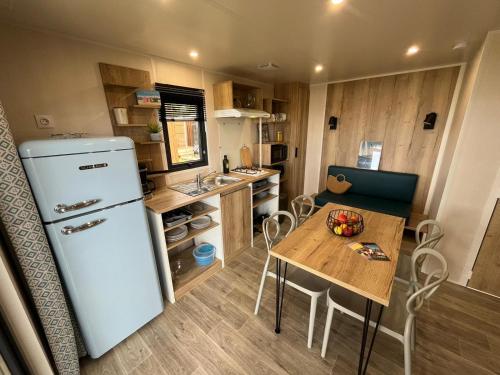 多吕多勒龙Camping Ostréa ****的一间带冰箱和桌子的小厨房