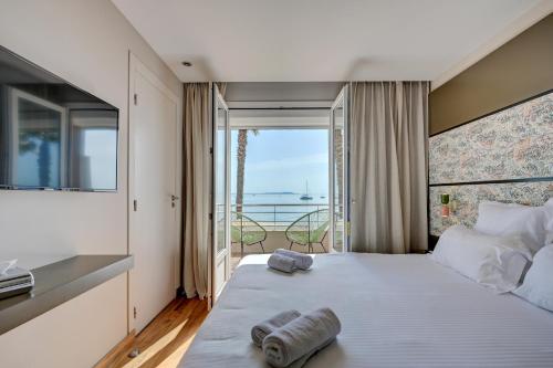 耶尔Hôtel Bor的一间卧室设有一张大床,享有海景