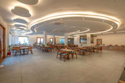 兰纳加Evara Spa & Resort的一间在房间内配有桌椅的餐厅