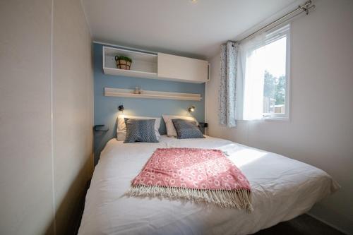 HenxelCamping het Wieskamp的一间卧室配有一张床铺,床上铺有红色毯子