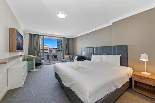 悉尼Comfy Studio Next to Chatswood Station的一间带大床的卧室和一间客厅
