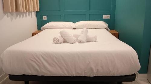 桑提亚纳德玛Resort Camping Santillana del Mar的一张带两个枕头的床和两条毛巾