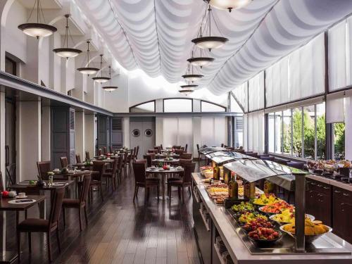 马德里铂尔曼马德里机场展会酒店的餐厅设有桌椅,并展示食物