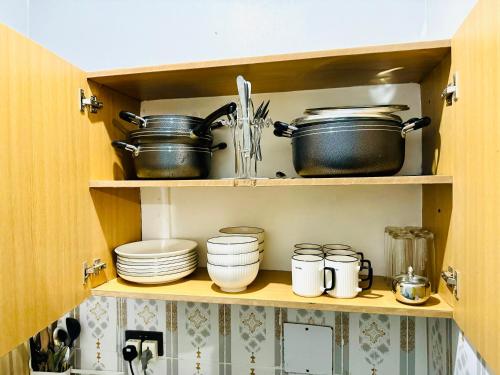 AruaFivas Residences的装满锅碗瓢盆和盘子的橱柜