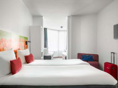 阿姆斯特丹全季 - 雅高酒店的酒店客房 - 带两张带红色枕头的床
