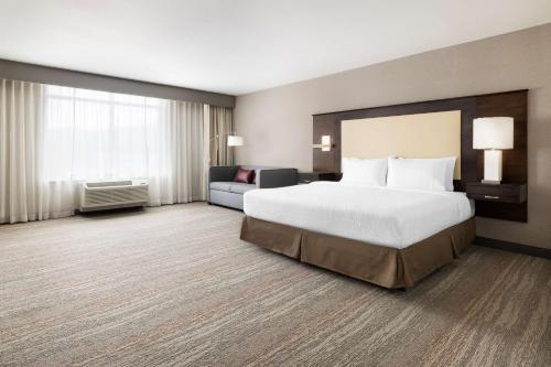 纳帕加州纳帕汉普顿酒店及套房的大型酒店客房,配有床和沙发