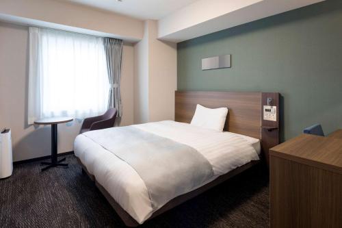 东京东京东神田舒适酒店(Comfort Hotel Tokyo Higashi Kanda)的酒店客房设有床和窗户。