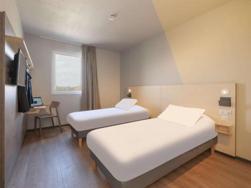 蒙德马桑Ibis Budget Mont De Marsan的酒店客房配有两张床和一张书桌