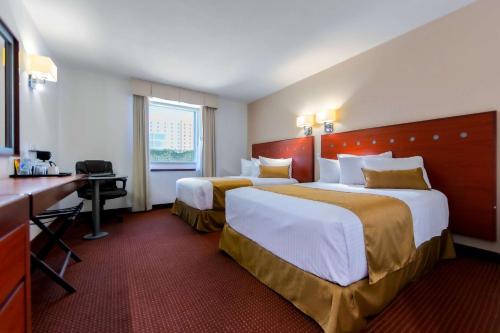 克雷塔罗Comfort Inn Queretaro Tecnologico的酒店客房配有两张床和一张书桌