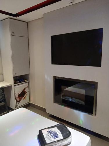 阿雷格里港Deslize Motel的客厅设有壁炉和平面电视。