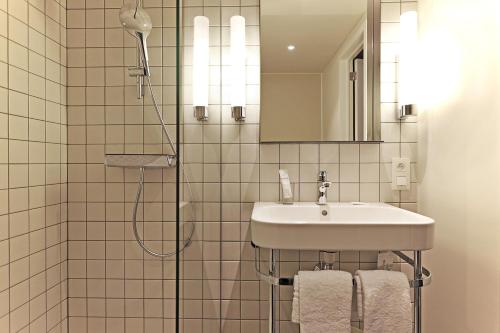 布鲁塞尔Hotel Van Belle的白色的浴室设有水槽和淋浴。