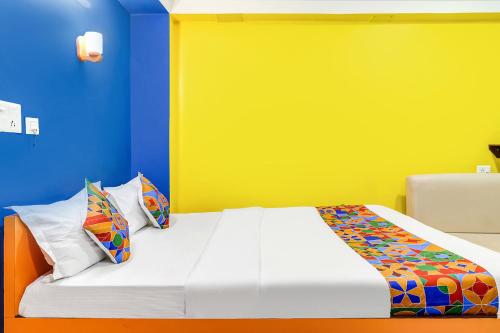 BāghdograFabHotel Relax的一间卧室配有一张黄色和蓝色墙壁的床
