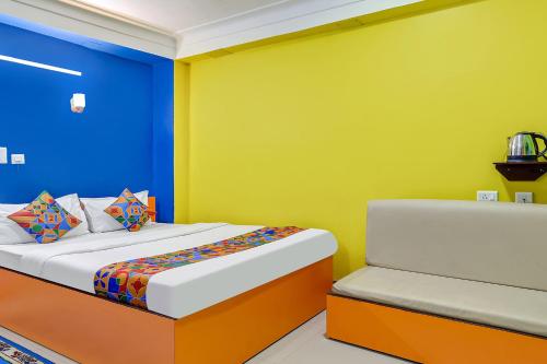 BāghdograFabHotel Relax的一间卧室设有一张床,墙壁为蓝色和黄色