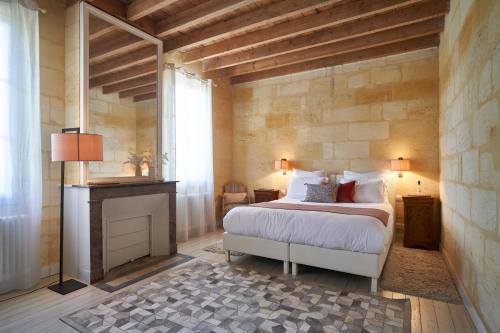 利布尔讷Château Bonalgue - Pomerol的一间卧室设有一张大床和一个壁炉