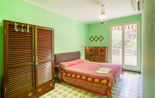 里奥马里纳3 Bedroom Nice Apartment In Rio Marina的一间卧室设有床铺、绿色的墙壁和窗户