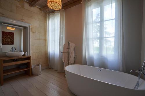 利布尔讷Château Bonalgue - Pomerol的一间带大浴缸和水槽的浴室