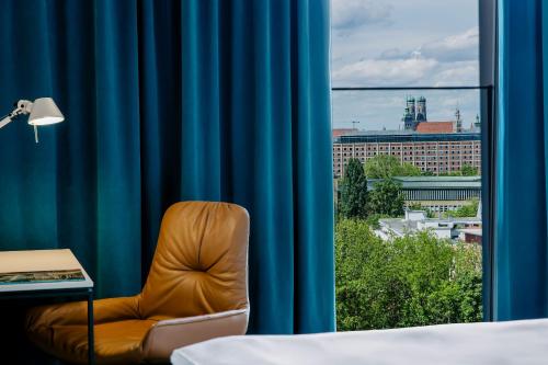 慕尼黑慕尼黑德意志博物馆一号汽车旅馆的窗前的椅子,带蓝色窗帘