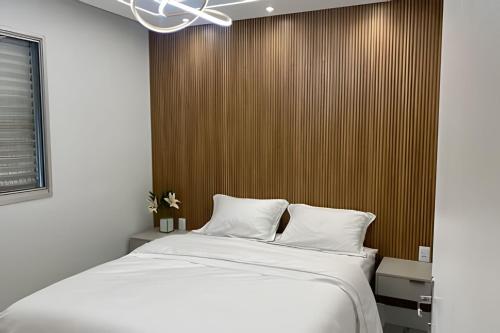 圣保罗Ap 5 estrelas, próx aero “CGH”的一间卧室设有一张床和木墙
