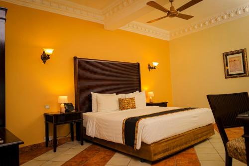 达累斯萨拉姆斗兽场精品酒店&Spa的一间卧室设有一张黄色墙壁的床