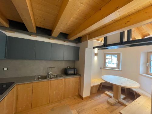 Le GrazieChalet Le Grazie的厨房配有木制橱柜、水槽和桌子
