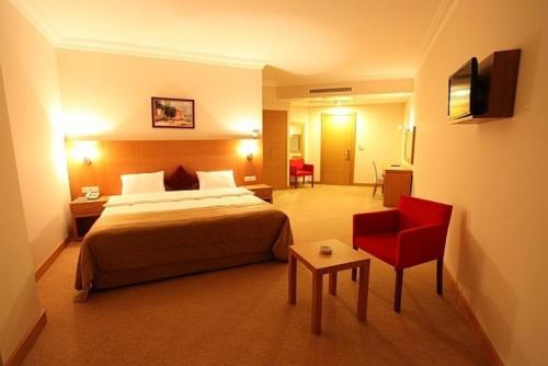 Velimeşe新罗酒店的酒店客房,配有一张床和一张红色椅子