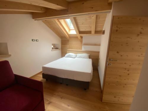Le GrazieChalet Le Grazie的小房间设有一张床和一把红色椅子