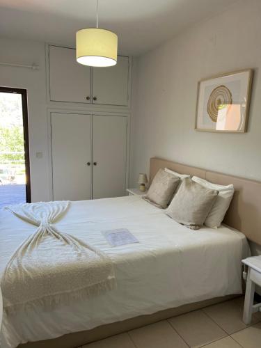 吉尔斯Cantinho das Oliveiras的卧室配有一张带灯的白色大床