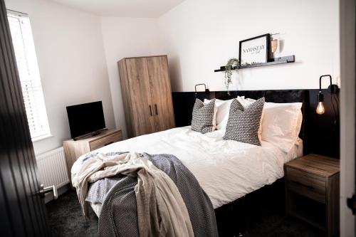阿什顿下安林恩Urban Loft Apartment • 2 Bedroom • Manchester的一间卧室配有带白色床单和枕头的床。