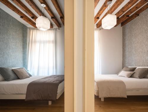威尼斯Erbaria Boutique Apartment R&R的一间卧室设有两张床和窗户。