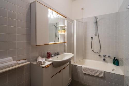 贝拉诺STUNNING APARTMENT- Terrace and Swimming Pool的白色的浴室设有水槽和淋浴。