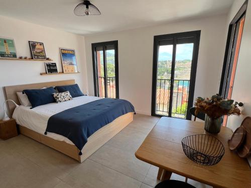 科利尤尔Canta la Mar - Vue exceptionnelle的卧室配有床、桌子和窗户。