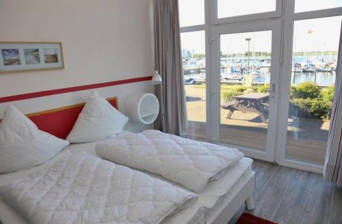 费曼城堡Am Rundsteg 4的卧室配有一张床,享有码头的景色